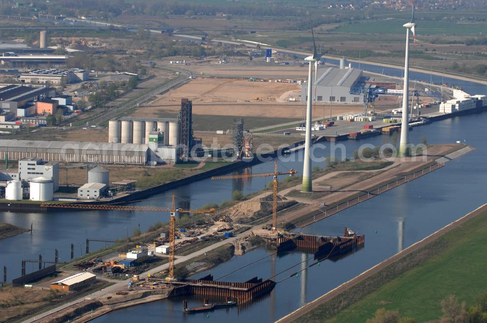 Magdeburg from above - Blick auf die Baustelle der Niedrigwasserschleuse an der Steinkopfinsel im Hafen Magdeburg an der Elbe. Umflossen wird die Steinkopfinsel im Osten von der Elbe und dem Abstiegskanal Rothensee, sowie im Westen vom Zweigkanal Magdeburg. Die Insel ist ca. 2,5 km lang und ca. 0,3 km breit (an der stärksten Stelle). Der Binnenhafen ist in vier Güterumschlagplätze eingeteilt, der Handelshafen, Industriehafen, Kanalhafen und der Hanseshafen. Das Gebiet verteilt sich über die Stadtteile Alte-Neustadt, Industriehafen und Gewerbegebiet Nord. Jedoch hat der Handelshafen für die Schiffahrt heute keine Bedeutung mehr, dieser Bereich wird stetig zum Wissenschaftsstandort umgebaut. Kontakt: Magdeburger Hafen GmbH, Saalestraße 20, 39126 Magdeburg, Tel. +49(0)391 5939-0, Fax +49(0)391 5616648, email: Logistik@magdeburg-hafen.de; Kontakt WSV: Wasserstraßen-Neubauamt Magdeburg, 39106 Magdeburg, Tel. +49(0)391 535-0, email: wna-magdeburg@wsv.bund.de