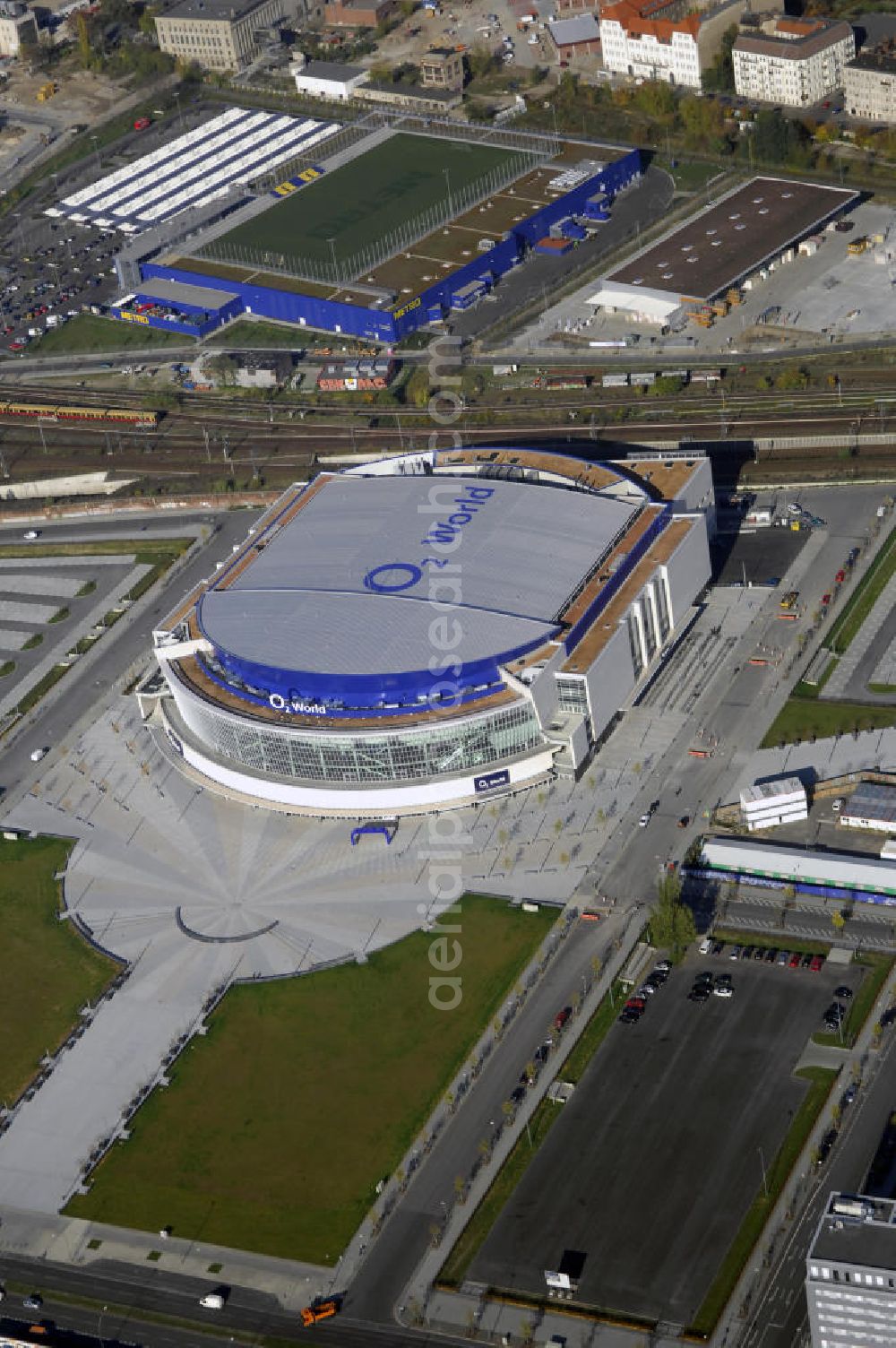 Aerial photograph Berlin - Blick auf die O2 World Arena in Berlin Friedrichshain. Die O2 World ist eine multifunktionale Veranstaltungshalle. Die Grundsteinlegung erfolgte im September 2006. Nach einer 2-jährigen Bauphase fand die Eröffnungsfeier im September 2008 statt. Mit bis zu 17.000 Sitz- und Stehplätzen, 59 Entertainment-Suiten ist die O2 World die größte Veranstaltungshalle Berlins und ermöglicht eine Vielzahl von Sport- und Musikevents. Bauherr und Investor ist die Anschutz Entertainment Group, die weltweit Arenen, Theater sowie verschiedene Tochterfirmen besitzt, betreibt und promotet. Die Firma O2 Germany hat die Namensrechte an der Arena in Berlin erworben. Kontakt: Anschutz Entertainment Group, Q 207 Friedrichstraße 76, 10117 Berlin, Tel. +49(0)30 2060708 0, Fax +49(0)30 2060708 111, Email: info@o2world.de