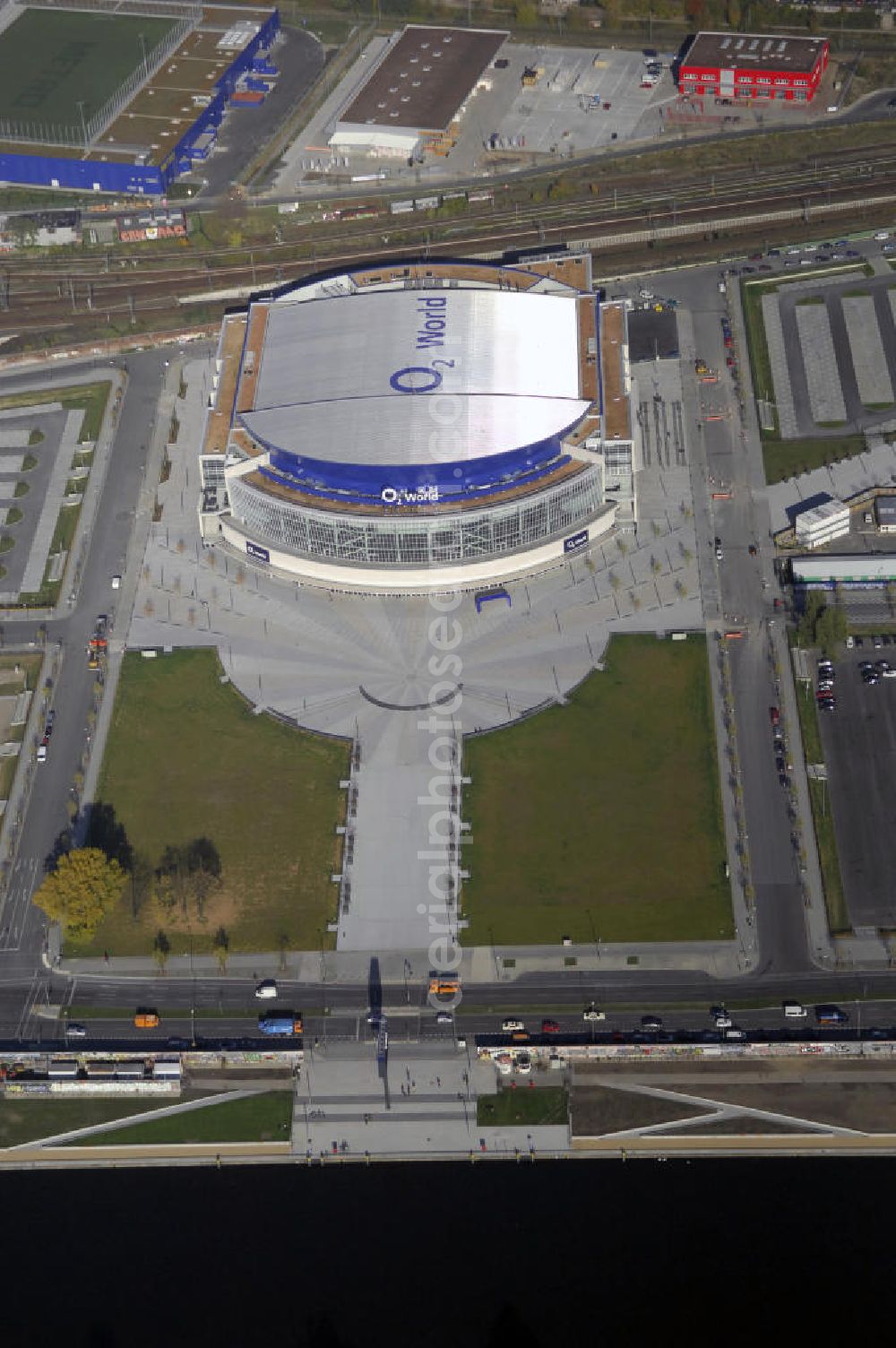 Berlin from above - Blick auf die O2 World Arena in Berlin Friedrichshain. Die O2 World ist eine multifunktionale Veranstaltungshalle. Die Grundsteinlegung erfolgte im September 2006. Nach einer 2-jährigen Bauphase fand die Eröffnungsfeier im September 2008 statt. Mit bis zu 17.000 Sitz- und Stehplätzen, 59 Entertainment-Suiten ist die O2 World die größte Veranstaltungshalle Berlins und ermöglicht eine Vielzahl von Sport- und Musikevents. Bauherr und Investor ist die Anschutz Entertainment Group, die weltweit Arenen, Theater sowie verschiedene Tochterfirmen besitzt, betreibt und promotet. Die Firma O2 Germany hat die Namensrechte an der Arena in Berlin erworben. Kontakt: Anschutz Entertainment Group, Q 207 Friedrichstraße 76, 10117 Berlin, Tel. +49(0)30 2060708 0, Fax +49(0)30 2060708 111, Email: info@o2world.de