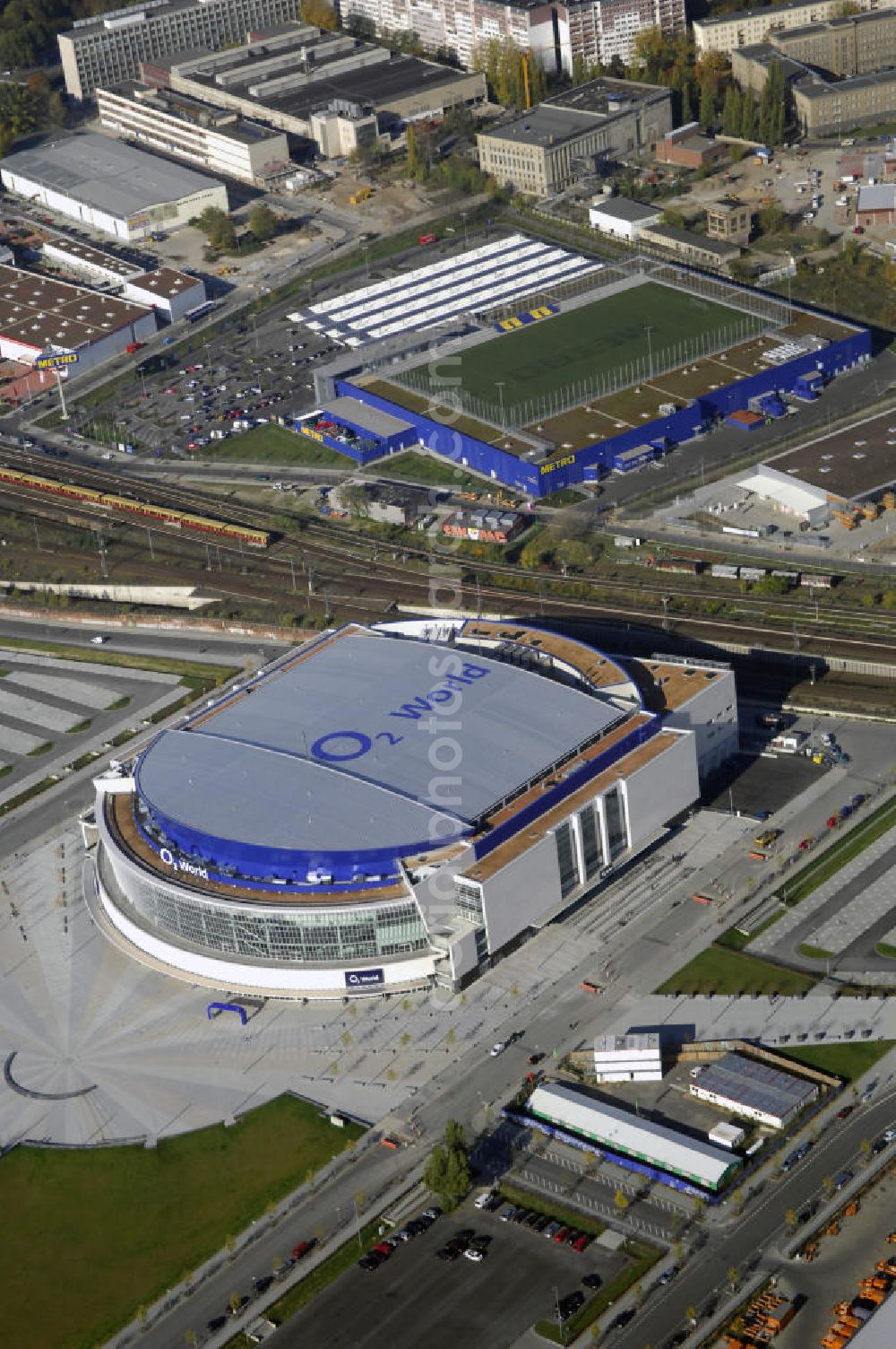 Berlin from above - Blick auf die O2 World Arena in Berlin Friedrichshain. Die O2 World ist eine multifunktionale Veranstaltungshalle. Die Grundsteinlegung erfolgte im September 2006. Nach einer 2-jährigen Bauphase fand die Eröffnungsfeier im September 2008 statt. Mit bis zu 17.000 Sitz- und Stehplätzen, 59 Entertainment-Suiten ist die O2 World die größte Veranstaltungshalle Berlins und ermöglicht eine Vielzahl von Sport- und Musikevents. Bauherr und Investor ist die Anschutz Entertainment Group, die weltweit Arenen, Theater sowie verschiedene Tochterfirmen besitzt, betreibt und promotet. Die Firma O2 Germany hat die Namensrechte an der Arena in Berlin erworben. Kontakt: Anschutz Entertainment Group, Q 207 Friedrichstraße 76, 10117 Berlin, Tel. +49(0)30 2060708 0, Fax +49(0)30 2060708 111, Email: info@o2world.de