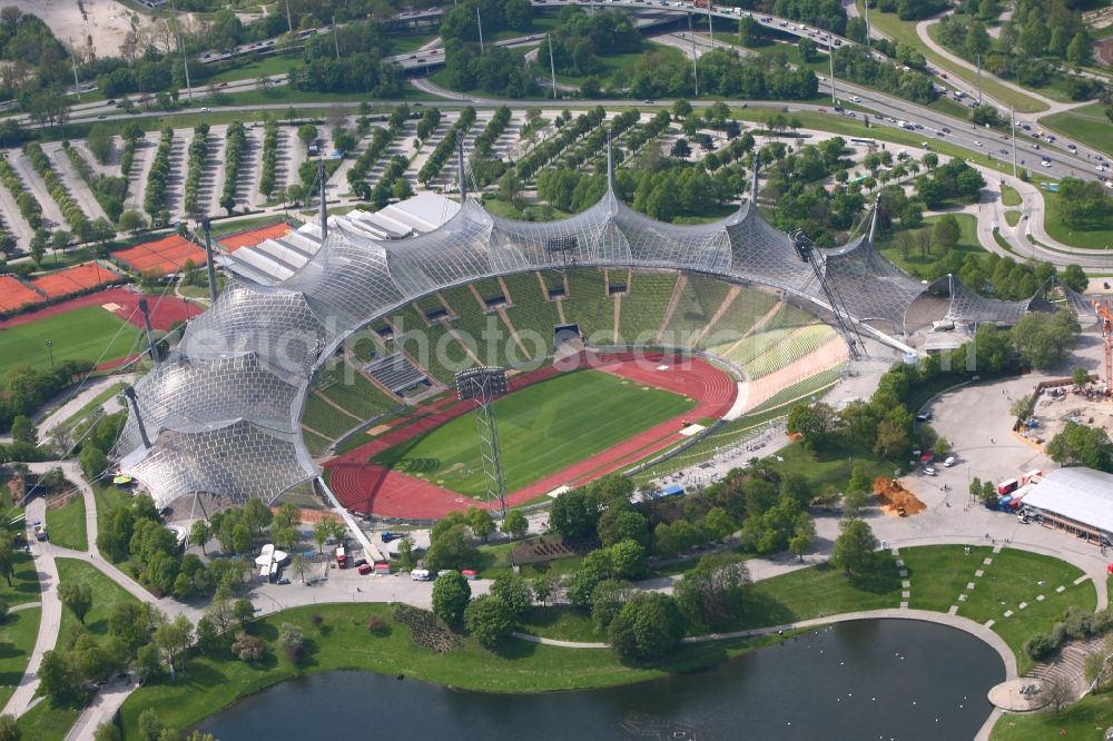 München from above - The Olympic Stadium Munich is the central sports venue in the Olympic Park and was capital of the 1972 Summer Olympics in Munich in Bavaria. The group of architects designed the modern Olympic Park Sports facility as part of the landscaping within the meaning of the concept of Olympic Games in the countryside. Thus, the system is designed as a stadium in the ground that is covered by a tent roof. After many years the stadium has been used as a football stadium it now serves mainly as a venue for cultural and athletic events