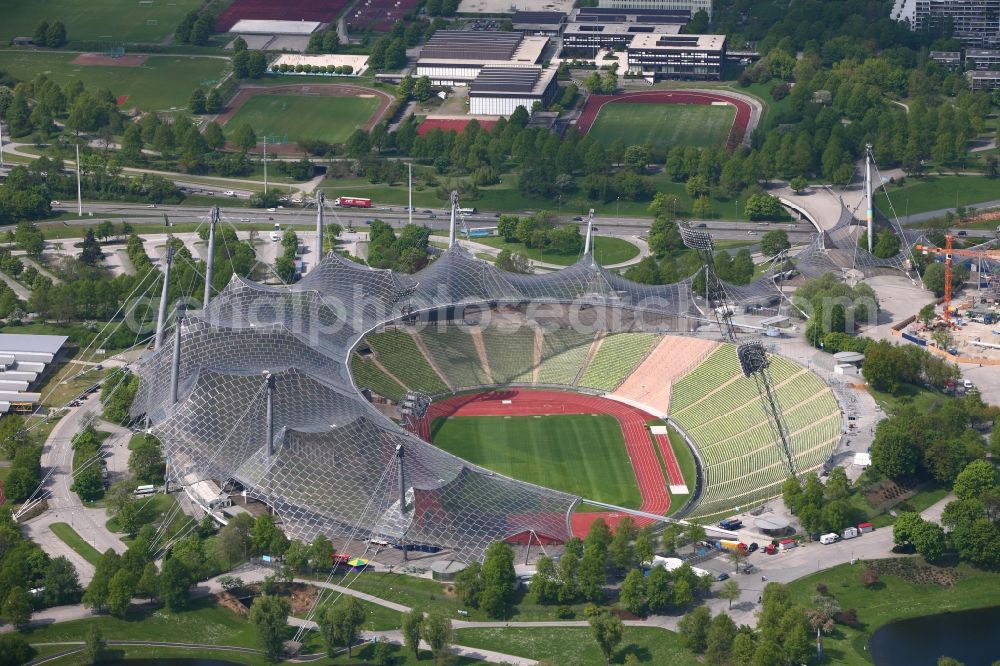 München from the bird's eye view: The Olympic Stadium Munich is the central sports venue in the Olympic Park and was capital of the 1972 Summer Olympics in Munich in Bavaria. The group of architects designed the modern Olympic Park Sports facility as part of the landscaping within the meaning of the concept of Olympic Games in the countryside. Thus, the system is designed as a stadium in the ground that is covered by a tent roof. After many years the stadium has been used as a football stadium it now serves mainly as a venue for cultural and athletic events