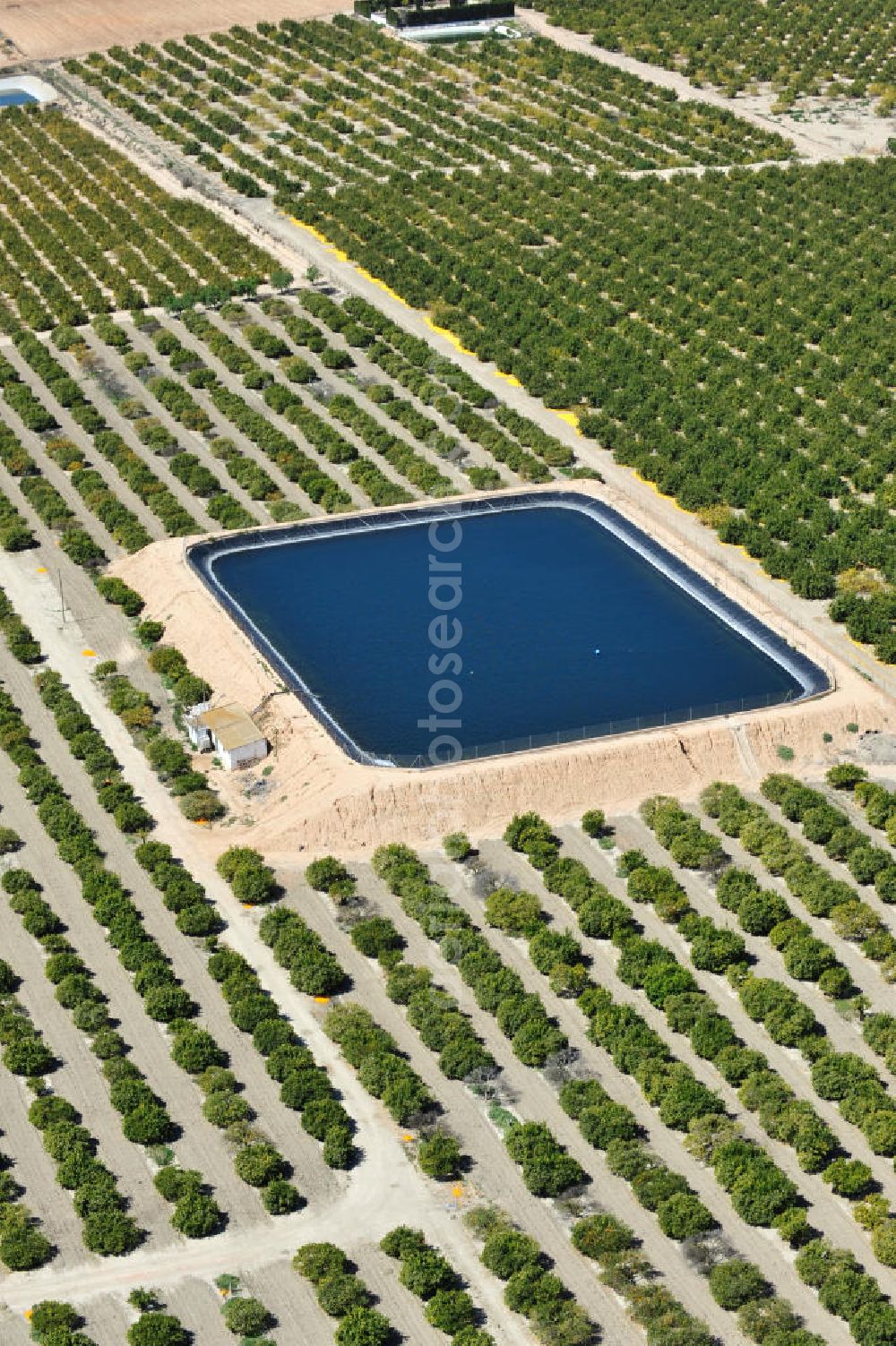 Los Martinez from the bird's eye view: Detention reservoir on irrigation levels for the cultivation of oranges and lemons near the city Los Martinez in Spain