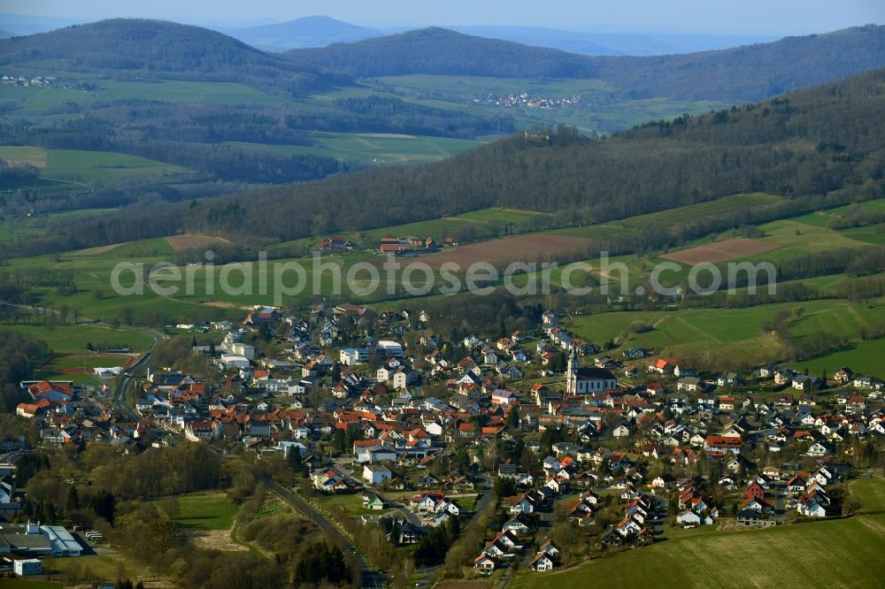 Aerial image Hilders - City view of the streets and houses of the residential areas in the valley surrounded by mountains in the Rhoen community of Hilders in the state of Hesse, Germany