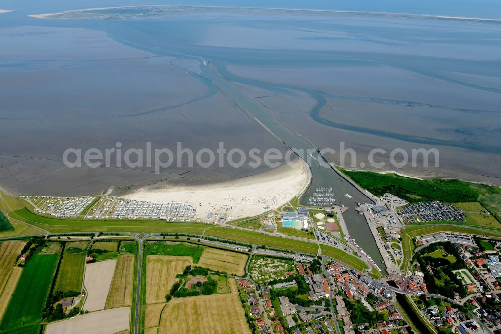 Aerial photograph Esens - Town View of the streets and houses of the residential areas in Bensersiel beneath the road Hauptstrasse aswell as nearby fields and a haven at the coastline of th north sea in the state Lower Saxony