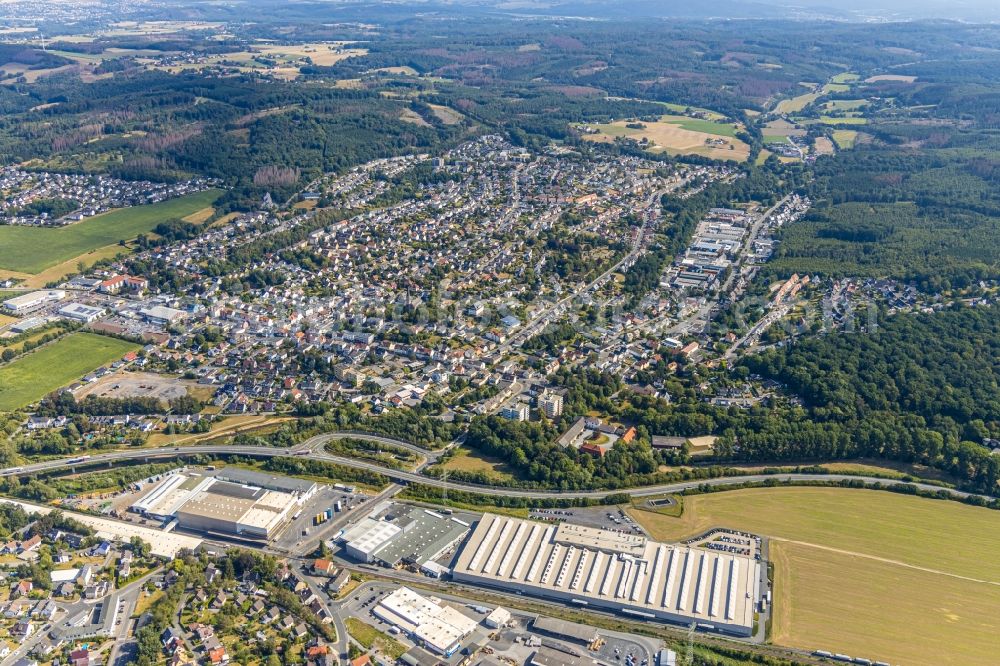 Aerial image Menden (Sauerland) - Surrounded by forest and forest areas center of the streets and houses and residential areas overlooking the factory premises and production facilities of OBO Bettermann Holding GmbH & Co. KG on Hueingser Ring - Fischkuhle in the district Lendringsen in Menden (Sauerland) in the state North Rhine-Westphalia, Germany