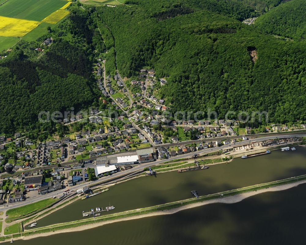 Aerial photograph Brohl-Lützing - Riverbank of the Rhine in Brohl-Luetzing in the state of Rhineland-Palatinate. On the riverbank of the borough, there is a football pitch, a green area and a small harbour pool. A forest on a hill slope is located behind the residential area