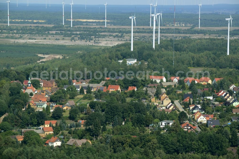 Kostebrau from above - View of the village of Kostebrau in the state of Brandenburg. The village is located in a forest. Wind turbines and wheels are located behind it