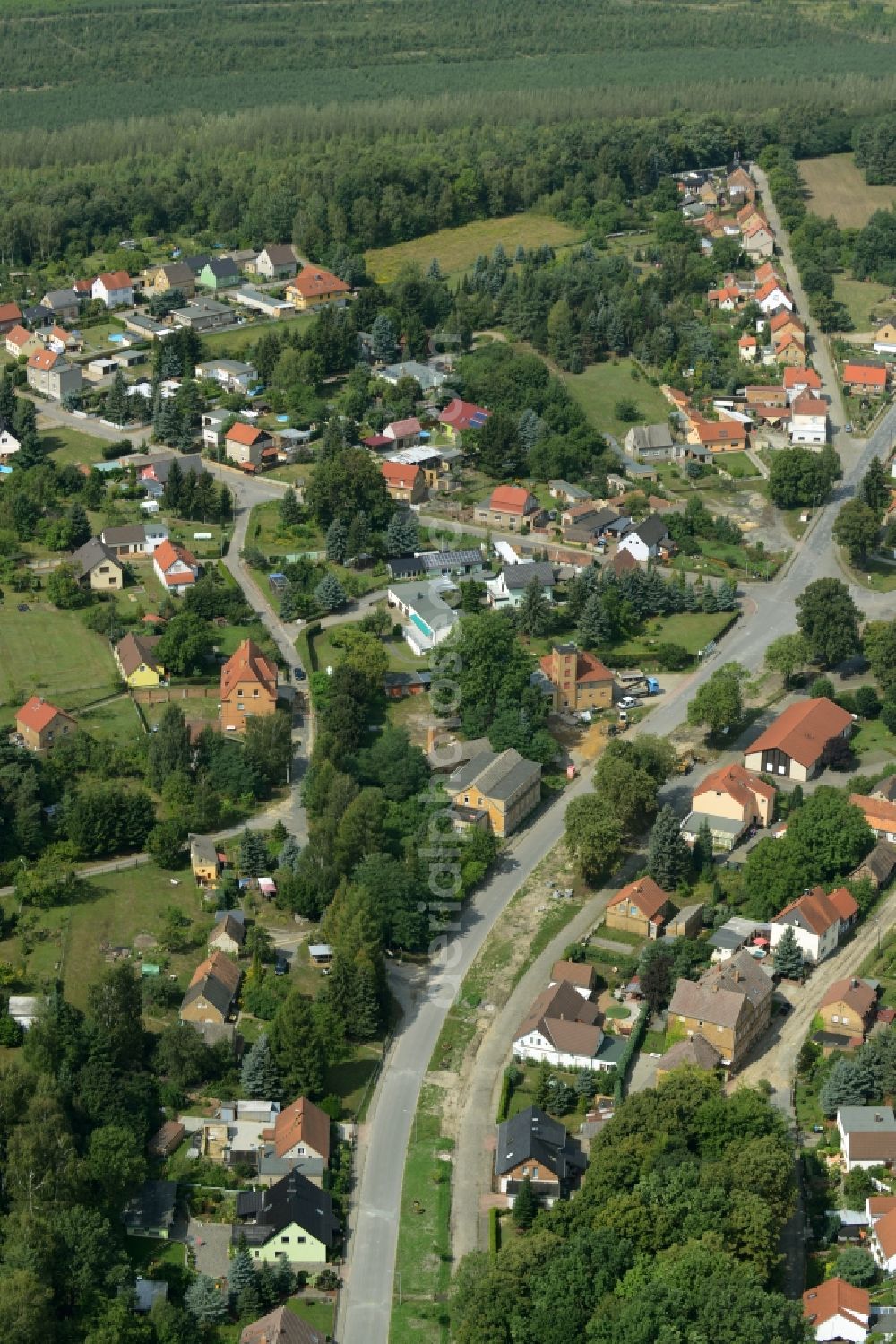 Aerial photograph Kostebrau - View of the village of Kostebrau in the state of Brandenburg. The village is located in a forest in a coal mining area. View along Ernst-Thaelmann-Strasse