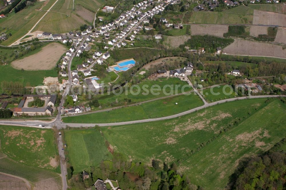 Mertesdorf from above - View of Mertesdorf in the state of Rhineland-Palatinate. Mertesdorf is a wine-growing village in the valley of the river Ruwer near Trier and an official resort. The village is surrounded by vineyards and hills and consists of historic and residential buildings. The outdoor pool Ruwertal can be seen