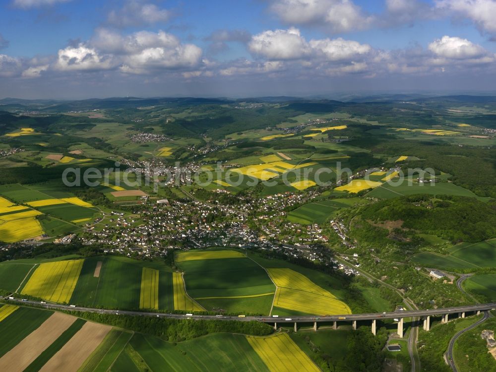 Niederzissen from the bird's eye view: View of the borough of Niederzissen in the state of Rhineland-Palatinate. The official tourist resort is located adjacent to the federal motorway A61 and close to a motorway bridge. The agricultural borough is surrounded by fields and meadows