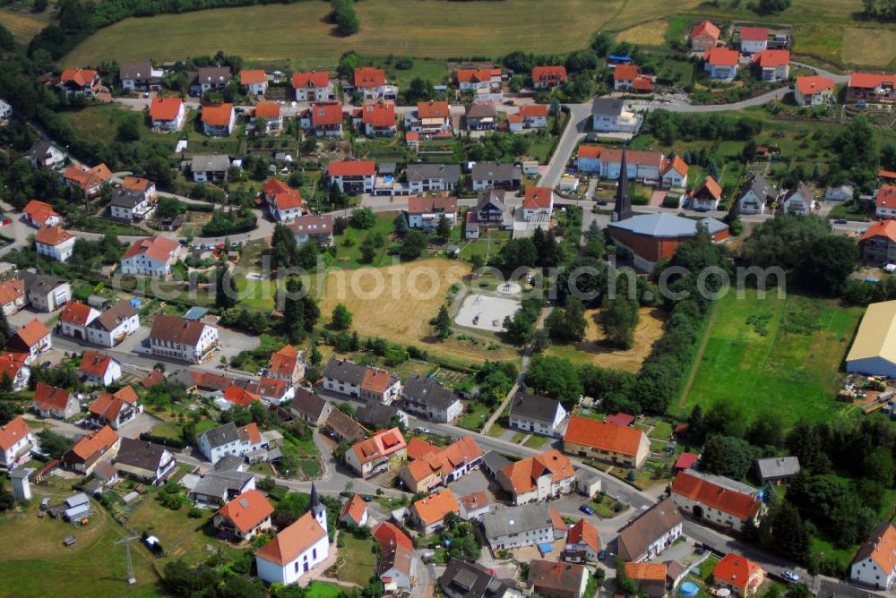 Schönenberg-Kübelberg / OT Ohmbach from the bird's eye view: Blick auf den Ort Ohmbach. Ohmbach ist eine Ortsgemeinde im Landkreis Kusel, entwickelte sich aus Ober- und Niederohmbach und wurde 977 als Ovenbach erstmals urkundlich erwähnt. 1793 efolgte die erste Vereinigung durch die französische Revolutionsarmee. 1936 wird der Ort nach fast 100 Jahren zum zweiten mal zusammengelegt. Der Wartturm ist Teil des Begehbaren Geschichtsbuches. Am rechten Bildrand ist die Kath. Liebfrauenkirche zu sehen. Kontakte: Liebfrauenkirche, Höferstraße, 66903 Ohmbach, Tel.: 063865675 / Verbandsverwaltung, Rathausstr. 8, 66901 Schönenberg-Kübelberg, Tel.: 06373-5040, E-Mail: poststelle@vgsk.rlp.de,