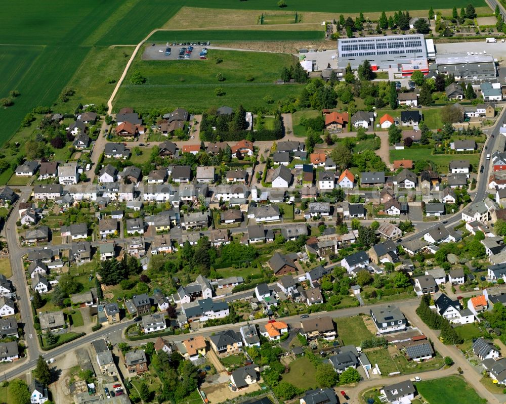 Bell (Hunsrück) from above - View of Bell in the state of Rhineland-Palatinate. The agricultural borough and municipiality is located in the county district of Rhine-Hunsrueck and is surrounded by meadows and rapeseed fields. Bell is an official tourist resort and characterised by its residential areas and the landscape of the Hunsrueck mountain range