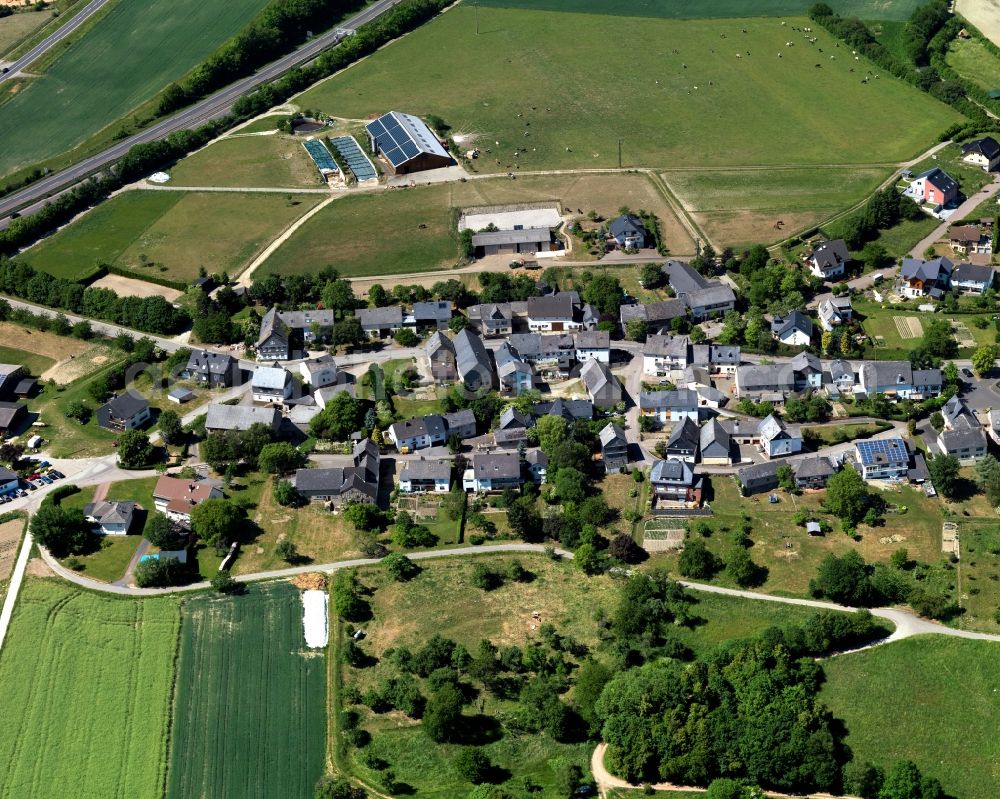 Hungenroth from the bird's eye view: View of the borough of Hungenroth in the state of Rhineland-Palatinate. The borough and municipiality is located in the county district of Rhine-Hunsrueck, in the foothills of the Hunsrueck region. The agricultural village consists of residential areas and is surrounded by fields and meadows. Hungenroth is located on federal motorway A61