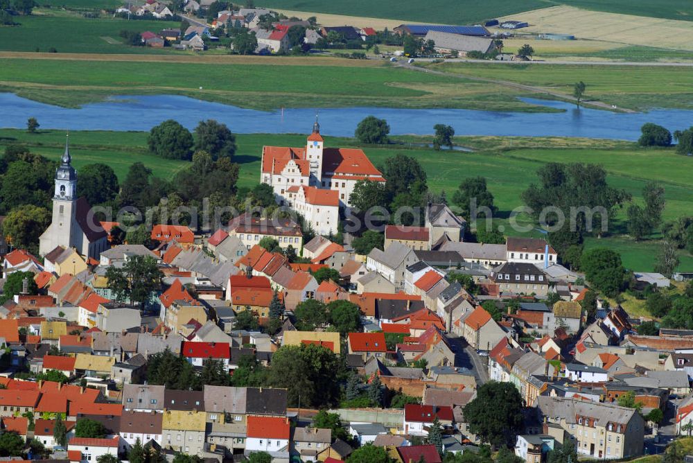 Pretzsch (an der Elbe) from the bird's eye view: Ortsansicht auf die Stadt Pretzsch an der Elbe mit Blick auf die Stadtkirche „St. Nikolaus“ und dem Schloss Pretzsch. Pretzsch liegt am Westufer der Elbe am nordwestlichen Rand des Naturparkes Dübener Heide. Stadt und Schloss liegen, von Hochwasserschutzdeichen umgeben, auf dem westlichen Elbufer. An der Stelle des Schlosses, das 1570 - 74 von dem damaligen Besitzer der alten gotischen Burganlage, Hans von Löser, erbaut wurde, stand bereits im Jahre 981 ein Burgward. Damit gehört das jetzige Schloss zu den ältesten Befestigungsanlagen im Bereich der Dübener Heide. Als Sachsen nach dem Befreiungskrieg gegen Napoleon 1815 Teile seines Landes an Preußen abgeben musste, kam auch Pretzsch in preußischen Besitz. Das Schloss wurde dem „Großen Potsdamschen Militärwaisenhaus“ übergeben. 1829 kamen die ersten Waisenkinder in das Schloss. Nach dem zweiten Weltkrieg wurde das Schloss wieder ein Kinderheim. In der heutigen Adolf-Reichwein-Schule - Schloss Pretzsch werden seit 1960 Kinder und Jugendliche unterrichtet. Seit 1992 ist die Schule eine Sonderschule mit Ausgleichsklassen. Kontakt: Adolf-Reichwein-Schule - Schloss Pretzsch, Schlossbezirk 1, 06909 Pretzsch, Tel.: 034926/57166, E-Mail: adolf-reichwein-schule-pretzsc@t-online.de,