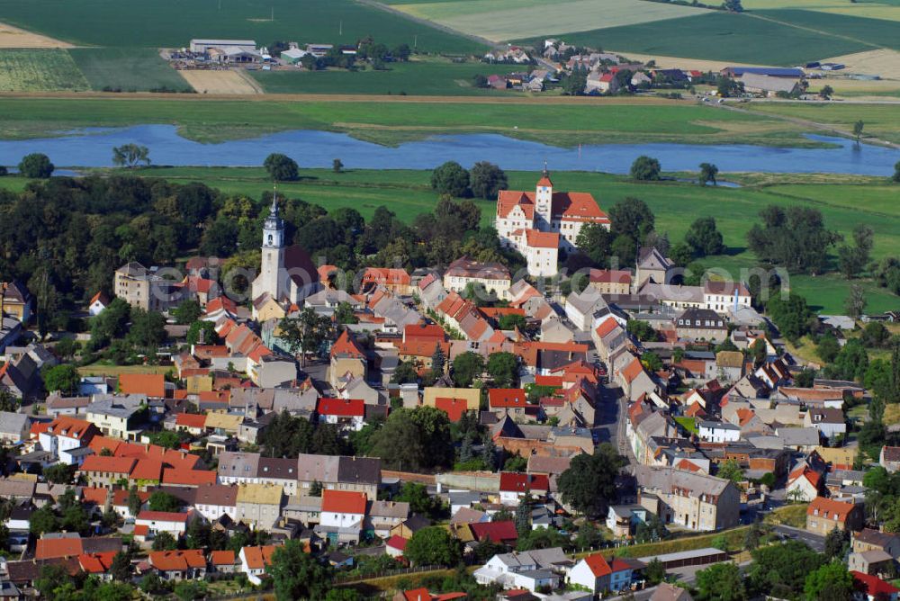 Aerial image Pretzsch (an der Elbe) - Ortsansicht auf die Stadt Pretzsch an der Elbe mit Blick auf die Stadtkirche „St. Nikolaus“ und dem Schloss Pretzsch. Pretzsch liegt am Westufer der Elbe am nordwestlichen Rand des Naturparkes Dübener Heide. Stadt und Schloss liegen, von Hochwasserschutzdeichen umgeben, auf dem westlichen Elbufer. An der Stelle des Schlosses, das 1570 - 74 von dem damaligen Besitzer der alten gotischen Burganlage, Hans von Löser, erbaut wurde, stand bereits im Jahre 981 ein Burgward. Damit gehört das jetzige Schloss zu den ältesten Befestigungsanlagen im Bereich der Dübener Heide. Als Sachsen nach dem Befreiungskrieg gegen Napoleon 1815 Teile seines Landes an Preußen abgeben musste, kam auch Pretzsch in preußischen Besitz. Das Schloss wurde dem „Großen Potsdamschen Militärwaisenhaus“ übergeben. 1829 kamen die ersten Waisenkinder in das Schloss. Nach dem zweiten Weltkrieg wurde das Schloss wieder ein Kinderheim. In der heutigen Adolf-Reichwein-Schule - Schloss Pretzsch werden seit 1960 Kinder und Jugendliche unterrichtet. Seit 1992 ist die Schule eine Sonderschule mit Ausgleichsklassen. Kontakt: Adolf-Reichwein-Schule - Schloss Pretzsch, Schlossbezirk 1, 06909 Pretzsch, Tel.: 034926/57166, E-Mail: adolf-reichwein-schule-pretzsc@t-online.de,