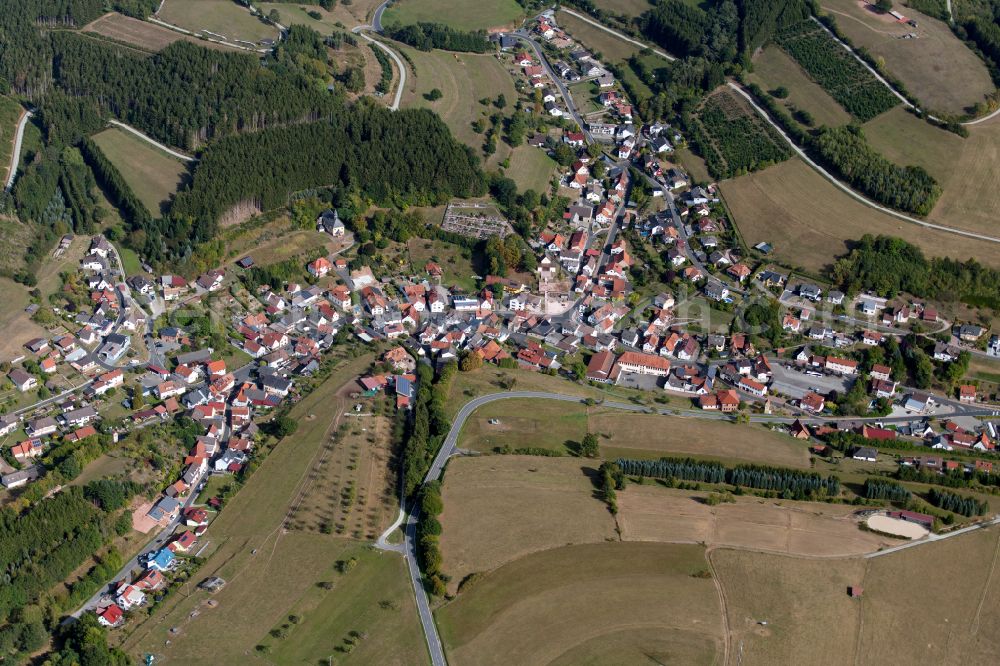 Aura im Sinngrund from above - Village view on the edge of agricultural fields and land in Aura im Sinngrund in the state Bavaria, Germany