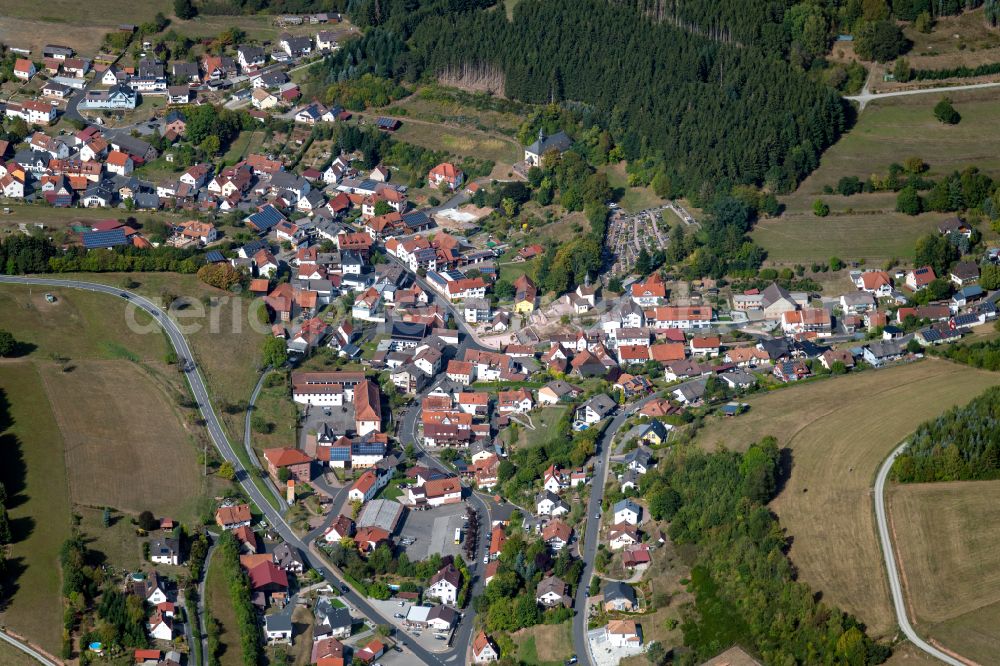 Aura im Sinngrund from above - Village view on the edge of agricultural fields and land in Aura im Sinngrund in the state Bavaria, Germany