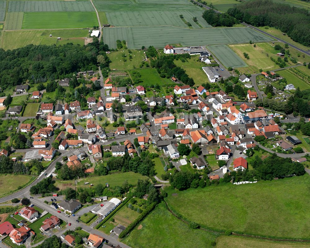 Flensungen from the bird's eye view: Village view on the edge of agricultural fields and land in Flensungen in the state Hesse, Germany