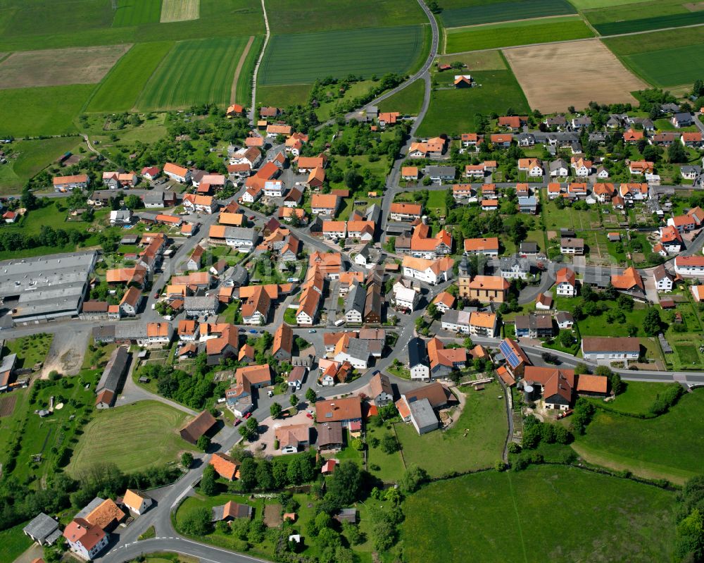 Frischborn from above - Village view on the edge of agricultural fields and land in Frischborn in the state Hesse, Germany