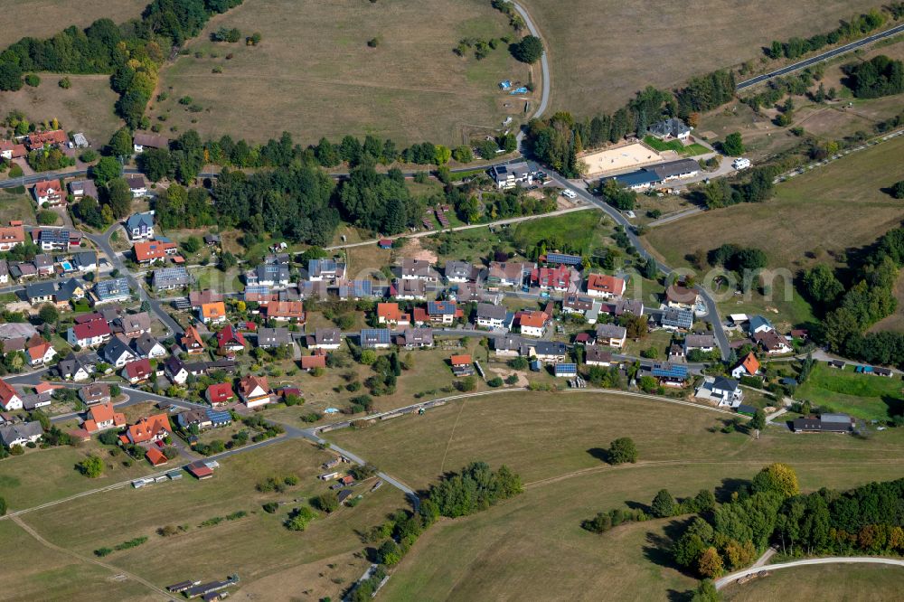 Neuhütten from above - Village view on the edge of agricultural fields and land in Neuhütten in the state Bavaria, Germany