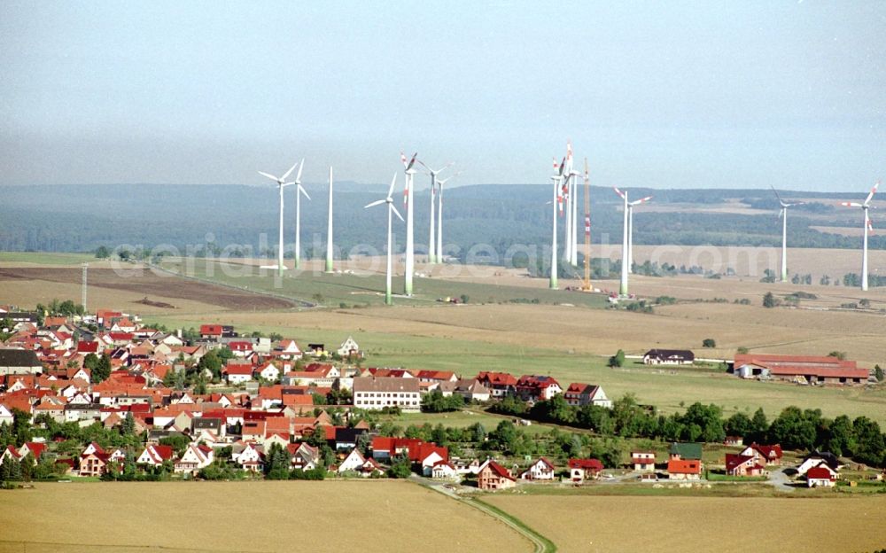 Dingelstädt from the bird's eye view: City view with silhouette of a group of wind power plants in Dingelstaedt in the state Thuringia, Germany