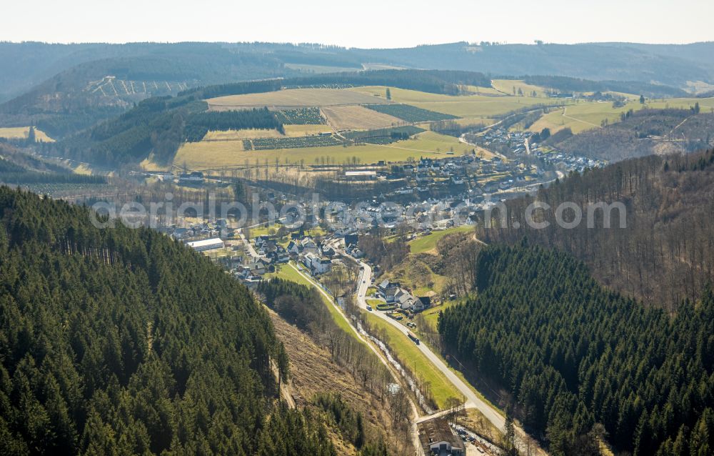 Oberkirchen from the bird's eye view: Location view of the streets and houses of residential areas in the valley landscape surrounded by mountains in Oberkirchen at Sauerland in the state North Rhine-Westphalia, Germany