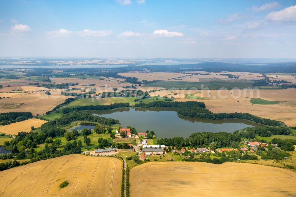 Schwinkendorf from the bird's eye view: Town View of the streets and houses of Ulrichshusen with the hotel castle Ulrichshusen and the Ulrichshuser lake with surrounding fields at Seestreet in Schwinkendorf in the state Mecklenburg - Western Pomerania