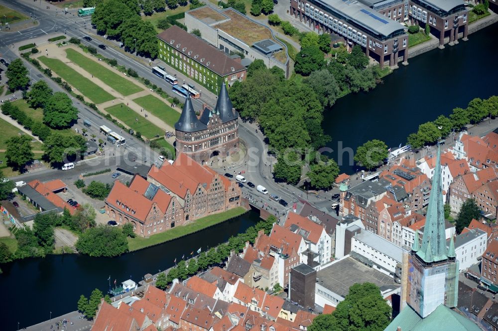 Aerial image Lübeck - Village on the banks of the river course of the Trave with the museum Holstentor in Luebeck in the state Schleswig-Holstein