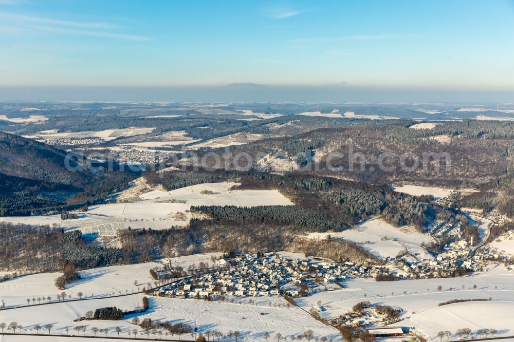 Olsberg from the bird's eye view: Winterly snowy view on the district Elleringhausen and its surrounding fields and forestland in Olsberg in the state North Rhine-Westphalia