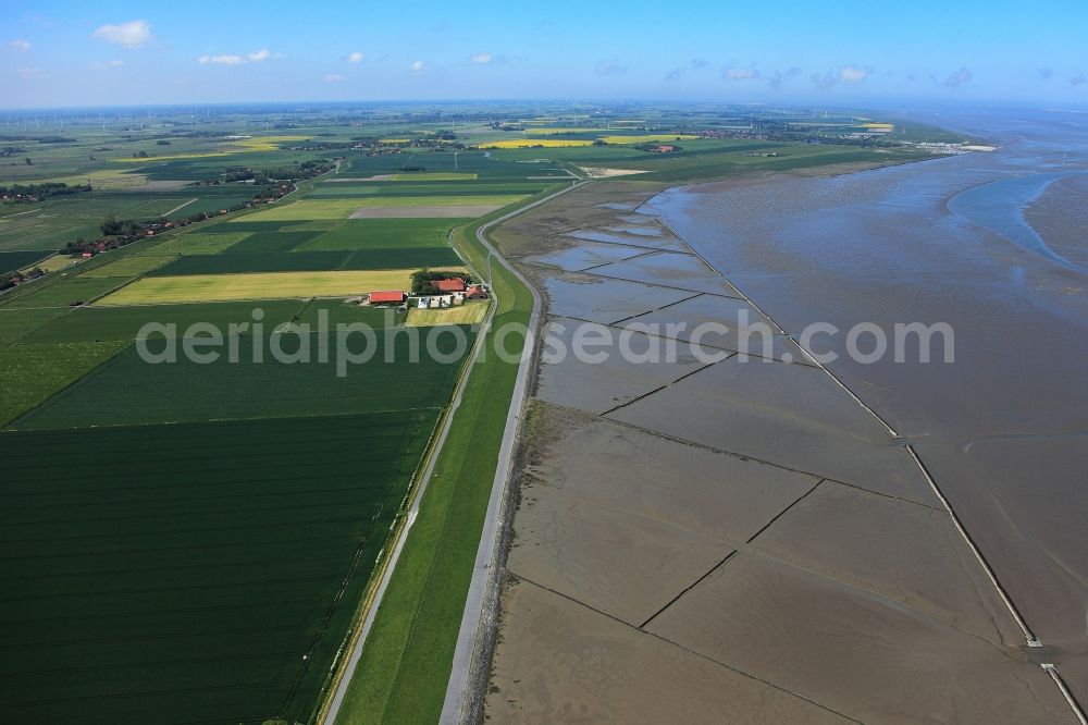 Neuharlingersiel from the bird's eye view: East Frisian Coast in Neuharlingersiel in the state of Lower Saxony. The borough of Neuharlingersiel is located in Harlinger Land in East Frisia on the North Sea shore. The coastal line consists of the Lower Saxony Wadden Sea which has been named a UNESCO world heritage site in 2009. The landscape is characterised by Wadden Sea, agriculture and fields