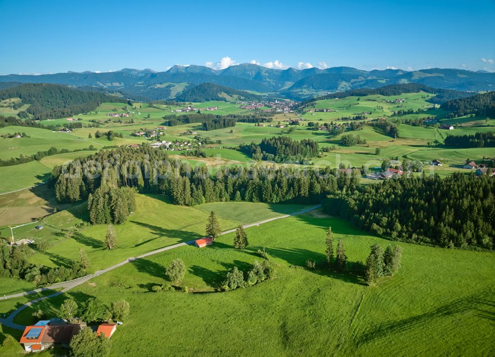 Aerial image Sulzberg - Panoramic perspective forest areas in with meadow landscape on street Dorf in Sulzberg in Vorarlberg, Austria