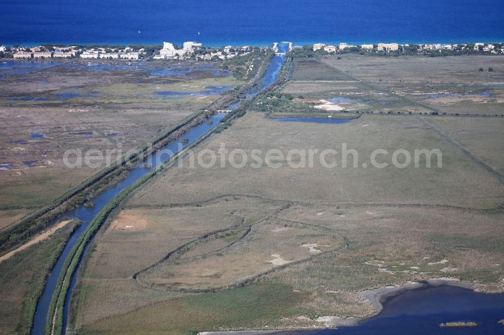 Aerial image Muro - Parc natural de s'Albufera de Mallorca or Parque natural de la Albufera de Mallorca with Ponds and Morast- water surface in a pond landscape in Muro in Balearic Islands, Spain