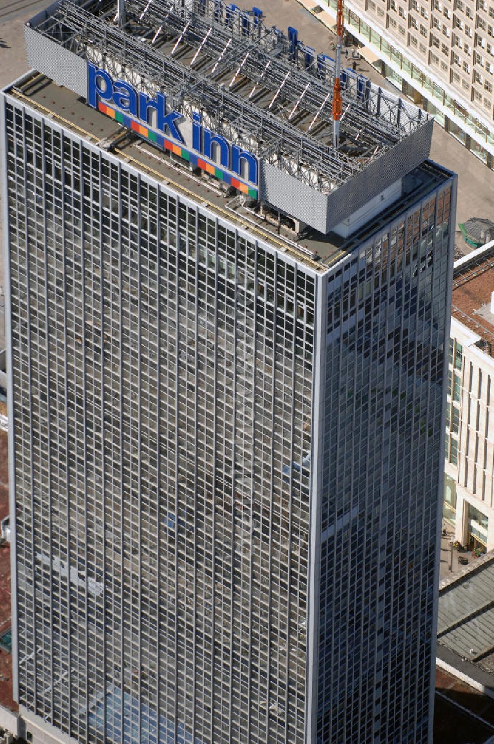 Aerial photograph Berlin - Blick auf das Hotel park inn am Alexanderplatz in Berlin. Das zwischen 1967 und 1970 errichtete Hotel ist rund 120 Meter hoch. Seit Oktober 2006 befinden sich zwei 35 Meter hohe Masten für Antennen auf dem Dach. Dadurch hat das Gebäude nun eine Gesamthöhe von 149,5 Metern und ist damit das dritthöchste Gebäude Berlins nach dem Fernsehturm und dem für die Öffentlichkeit nicht zugänglichen Fernmeldeturm auf dem Schäferberg. Das Hochhaus ist das höchste reine Hotelgebäude Deutschlands und zugleich das drittgrößte deutsche Hotel. Eröffnet wurde es 1970 als Interhotel Stadt Berlin mit 2.000 Betten. Es handelte sich um ein Vier-Sterne-Hotel, in dem bevorzugt Delegationen der Staaten des Warschauer Paktes untergebracht wurden. Zum damaligen Zeitpunkt waren die schnellen Aufzüge bemerkenswert. Seit 2003 ist es das Vier-Sterne-Hotel park inn Berlin Alexanderplatz mit 1.006 Zimmern, betrieben von der belgischen Rezidor-Gruppe. Im Panoramarestaurant in der 37. Etage befindet sich heute ein Casino - das höchste in Europa.