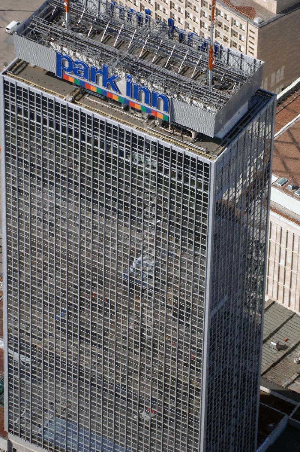 Berlin from the bird's eye view: Blick auf das Hotel park inn am Alexanderplatz in Berlin. Das zwischen 1967 und 1970 errichtete Hotel ist rund 120 Meter hoch. Seit Oktober 2006 befinden sich zwei 35 Meter hohe Masten für Antennen auf dem Dach. Dadurch hat das Gebäude nun eine Gesamthöhe von 149,5 Metern und ist damit das dritthöchste Gebäude Berlins nach dem Fernsehturm und dem für die Öffentlichkeit nicht zugänglichen Fernmeldeturm auf dem Schäferberg. Das Hochhaus ist das höchste reine Hotelgebäude Deutschlands und zugleich das drittgrößte deutsche Hotel. Eröffnet wurde es 1970 als Interhotel Stadt Berlin mit 2.000 Betten. Es handelte sich um ein Vier-Sterne-Hotel, in dem bevorzugt Delegationen der Staaten des Warschauer Paktes untergebracht wurden. Zum damaligen Zeitpunkt waren die schnellen Aufzüge bemerkenswert. Seit 2003 ist es das Vier-Sterne-Hotel park inn Berlin Alexanderplatz mit 1.006 Zimmern, betrieben von der belgischen Rezidor-Gruppe. Im Panoramarestaurant in der 37. Etage befindet sich heute ein Casino - das höchste in Europa.