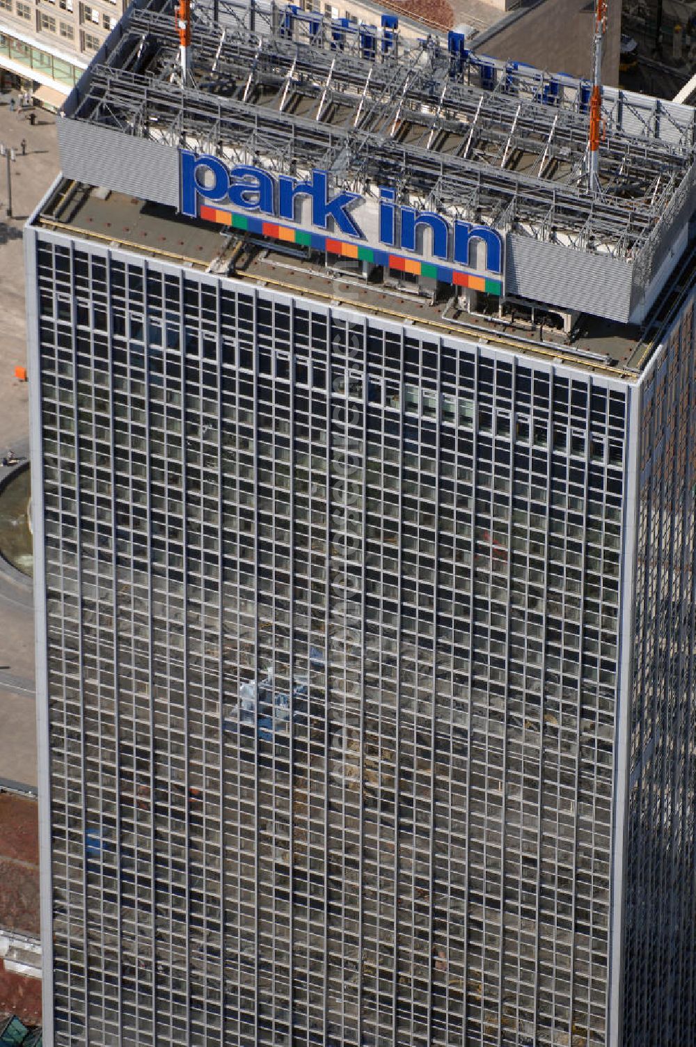 Aerial photograph Berlin - Blick auf das Hotel park inn am Alexanderplatz in Berlin. Das zwischen 1967 und 1970 errichtete Hotel ist rund 120 Meter hoch. Seit Oktober 2006 befinden sich zwei 35 Meter hohe Masten für Antennen auf dem Dach. Dadurch hat das Gebäude nun eine Gesamthöhe von 149,5 Metern und ist damit das dritthöchste Gebäude Berlins nach dem Fernsehturm und dem für die Öffentlichkeit nicht zugänglichen Fernmeldeturm auf dem Schäferberg. Das Hochhaus ist das höchste reine Hotelgebäude Deutschlands und zugleich das drittgrößte deutsche Hotel. Eröffnet wurde es 1970 als Interhotel Stadt Berlin mit 2.000 Betten. Es handelte sich um ein Vier-Sterne-Hotel, in dem bevorzugt Delegationen der Staaten des Warschauer Paktes untergebracht wurden. Zum damaligen Zeitpunkt waren die schnellen Aufzüge bemerkenswert. Seit 2003 ist es das Vier-Sterne-Hotel park inn Berlin Alexanderplatz mit 1.006 Zimmern, betrieben von der belgischen Rezidor-Gruppe. Im Panoramarestaurant in der 37. Etage befindet sich heute ein Casino - das höchste in Europa.