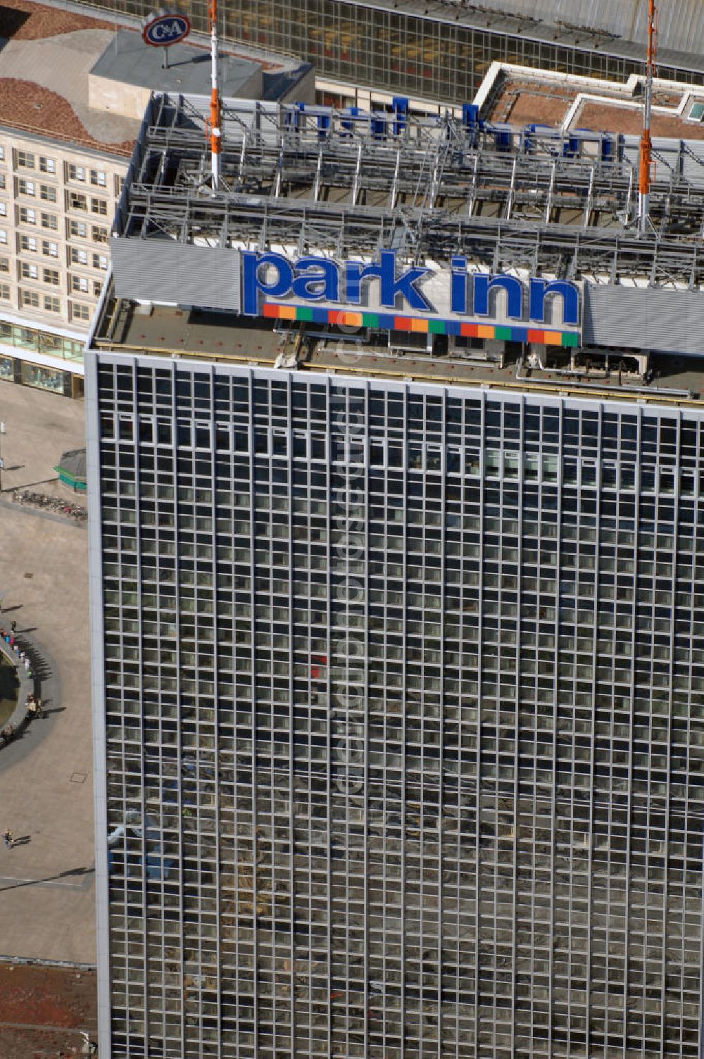 Berlin from above - Blick auf das Hotel park inn am Alexanderplatz in Berlin. Das zwischen 1967 und 1970 errichtete Hotel ist rund 120 Meter hoch. Seit Oktober 2006 befinden sich zwei 35 Meter hohe Masten für Antennen auf dem Dach. Dadurch hat das Gebäude nun eine Gesamthöhe von 149,5 Metern und ist damit das dritthöchste Gebäude Berlins nach dem Fernsehturm und dem für die Öffentlichkeit nicht zugänglichen Fernmeldeturm auf dem Schäferberg. Das Hochhaus ist das höchste reine Hotelgebäude Deutschlands und zugleich das drittgrößte deutsche Hotel. Eröffnet wurde es 1970 als Interhotel Stadt Berlin mit 2.000 Betten. Es handelte sich um ein Vier-Sterne-Hotel, in dem bevorzugt Delegationen der Staaten des Warschauer Paktes untergebracht wurden. Zum damaligen Zeitpunkt waren die schnellen Aufzüge bemerkenswert. Seit 2003 ist es das Vier-Sterne-Hotel park inn Berlin Alexanderplatz mit 1.006 Zimmern, betrieben von der belgischen Rezidor-Gruppe. Im Panoramarestaurant in der 37. Etage befindet sich heute ein Casino - das höchste in Europa.