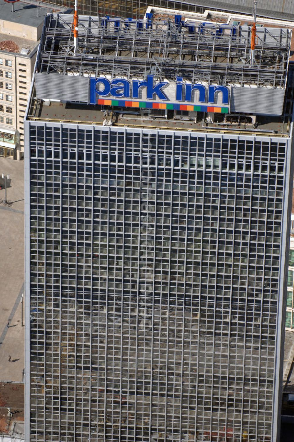 Berlin from the bird's eye view: Blick auf das Hotel park inn am Alexanderplatz in Berlin. Das zwischen 1967 und 1970 errichtete Hotel ist rund 120 Meter hoch. Seit Oktober 2006 befinden sich zwei 35 Meter hohe Masten für Antennen auf dem Dach. Dadurch hat das Gebäude nun eine Gesamthöhe von 149,5 Metern und ist damit das dritthöchste Gebäude Berlins nach dem Fernsehturm und dem für die Öffentlichkeit nicht zugänglichen Fernmeldeturm auf dem Schäferberg. Das Hochhaus ist das höchste reine Hotelgebäude Deutschlands und zugleich das drittgrößte deutsche Hotel. Eröffnet wurde es 1970 als Interhotel Stadt Berlin mit 2.000 Betten. Es handelte sich um ein Vier-Sterne-Hotel, in dem bevorzugt Delegationen der Staaten des Warschauer Paktes untergebracht wurden. Zum damaligen Zeitpunkt waren die schnellen Aufzüge bemerkenswert. Seit 2003 ist es das Vier-Sterne-Hotel park inn Berlin Alexanderplatz mit 1.006 Zimmern, betrieben von der belgischen Rezidor-Gruppe. Im Panoramarestaurant in der 37. Etage befindet sich heute ein Casino - das höchste in Europa.