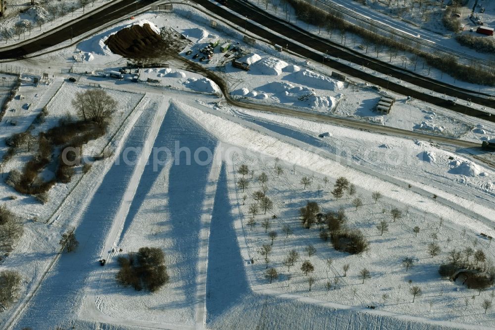 Aerial image Berlin - Winterly snowy area of the park Jelena-Santic-Friedenspark besides the road Hellersdorfer Strasse in Berlin in Germany