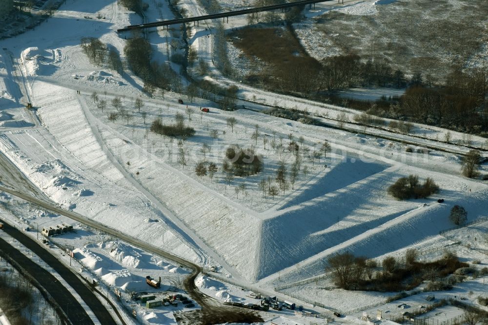 Berlin from above - Winterly snowy area of the park Jelena-Santic-Friedenspark besides the road Hellersdorfer Strasse in Berlin in Germany