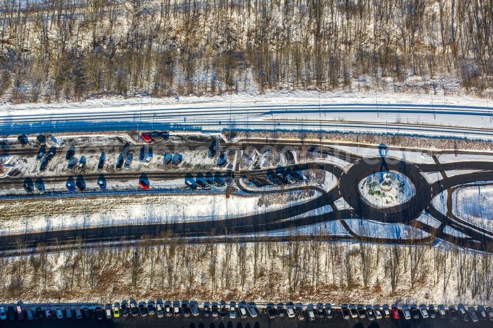 Aerial photograph Olsberg - Winterly snowy parking and storage space for automobiles beneath the road Stadionstrasse in Olsberg in the state North Rhine-Westphalia