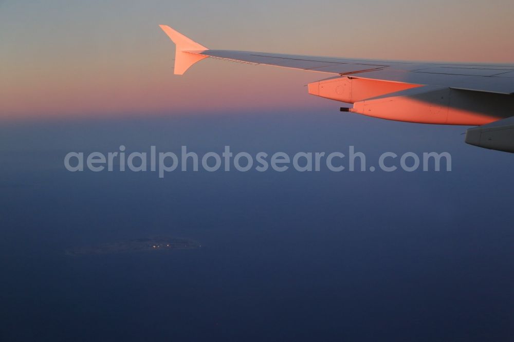 Aerial image Dubai - Wing of a passenger aircraft Airbus A380 over the Arabian Gulf approaching Dubai in the United Arab Emirates