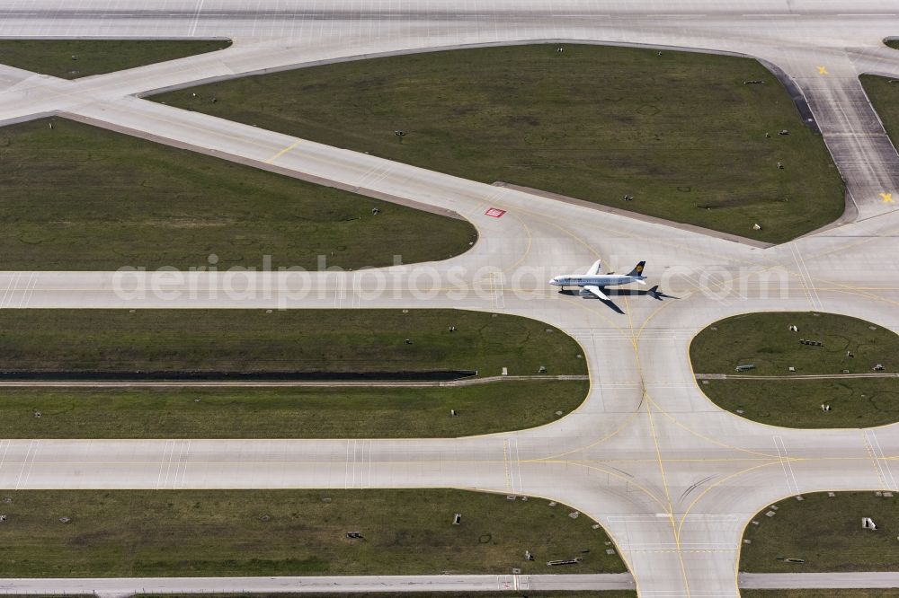 München-Flughafen from the bird's eye view: Airliner- Passenger aircraft A320 rolling on the apron of the airport in Muenchen-Flughafen in the state Bavaria, Germany