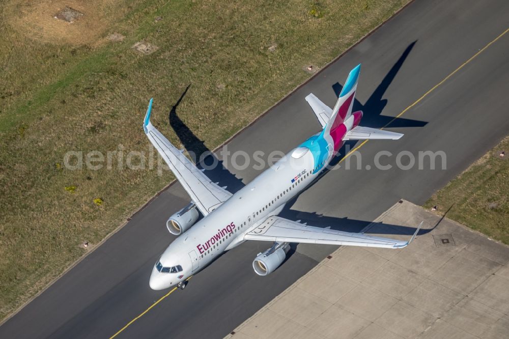 Aerial image Holzwickede - Airliner- Passenger aircraft A320-214 operated by eurowings with calling OE-IQC rolling on the apron of the airport in the district Brackel in Holzwickede in the state North Rhine-Westphalia, Germany