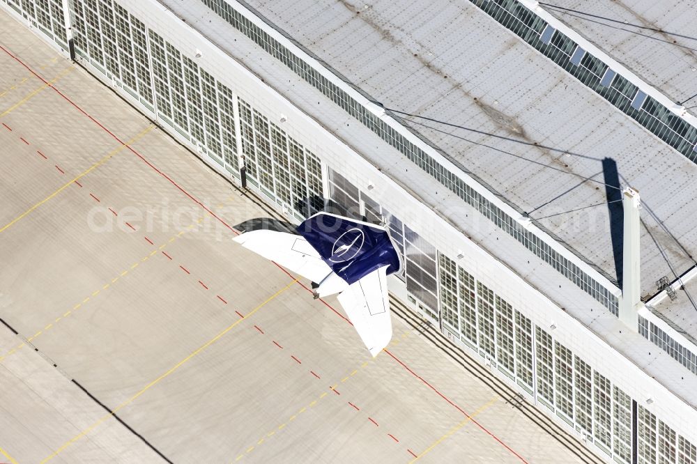 Aerial image München-Flughafen - Passenger airplane in Hangar abgestellt, nur das Seitenleitwerk schaut raus, in parking position - parking area at the airport in Muenchen-Flughafen in the state Bavaria, Germany