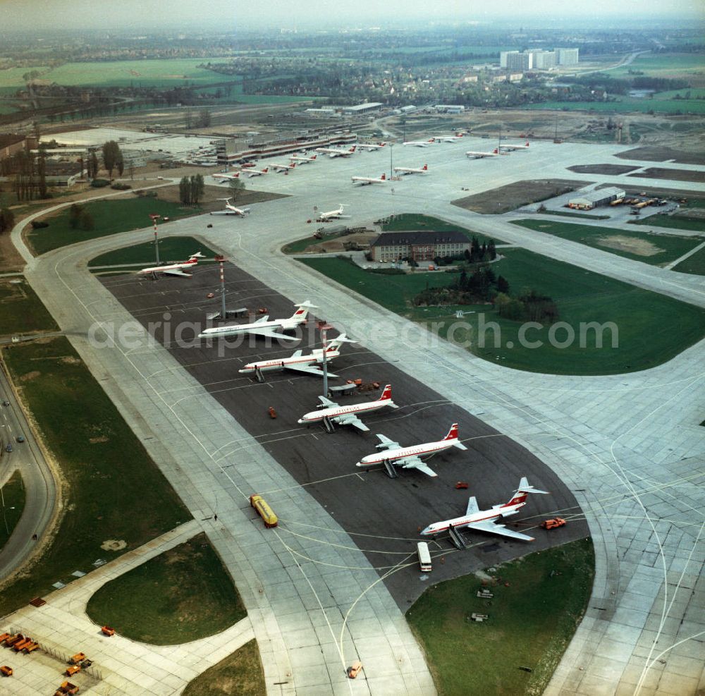 Schönefeld from the bird's eye view: Großraumflugzeuge / Passagierflugzeuge der Fluggesellschaften Interflug, Balkan Air und Aeroflot auf dem Flughafen Schönefeld bei Berlin. Flugzeugtypen (v.u.n.o.): Tupolev TU 134A der Interflug mit der Kennung DM SCT; Iljuschin IL 18 der Interflug mit der Kennung DM STO; Iljuschin IL 18 der Interflug mit der Kennung DM STE; Tupolew TU 154 der Balkan Air mit der Kennung LZ BTE; Iljuschin 62 der Aeroflot mit der Kennung CCCP 86616. Im Hintergrund das Empfangsgebäude mit weiteren parkenden Flugzeugen.