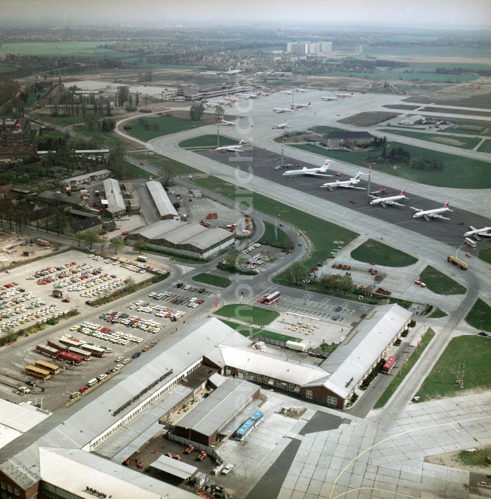 Schönefeld from the bird's eye view: Großraumflugzeuge / Passagierflugzeuge der Fluggesellschaften Interflug, Balkan Air und Aeroflot auf dem Flughafen Schönefeld. Flugzeugtypen (v.u.n.o.): Tupolev TU 134A der Interflug mit der Kennung DM SCT; Iljuschin IL 18 der Interflug mit der Kennung DM STO; Iljuschin IL 18 der Interflug mit der Kennung DM STE; Tupolew TU 154 der Balkan Air mit der Kennung LZ BTE; Iljuschin 62 der Aeroflot mit der Kennung CCCP 86616. Im Hintergrund das Empfangsgebäude mit weiteren parkenden Flugzeugen.