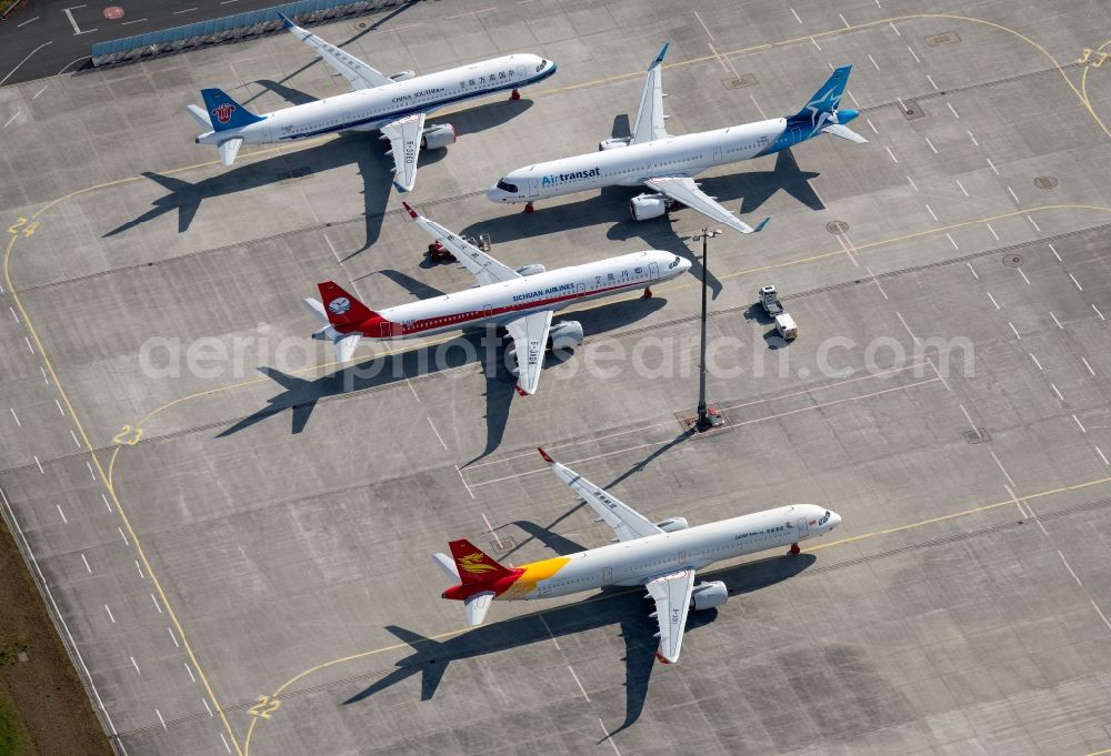 Erfurt from the bird's eye view: Brand-new passenger aircrafts of the type Airbus A321neo and A320neo covered in snow in winter before delivery to the parking position caused by the pandemic - parking area and alternative parking space at the Erfurt Weimar airport in the Bindersleben district of Erfurt in the state Thuringia, Germany