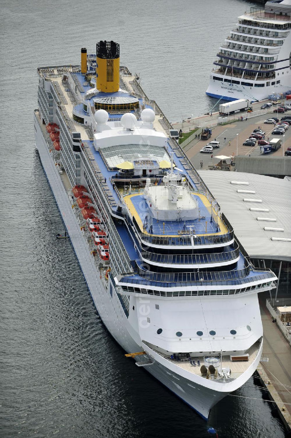 Aerial photograph Rostock - Warnemünde - Blick auf den Kreuzfahrt - Hafen in Warnemünde mit dem Passagierschiff COSTA ATLANTICA . Die Costa Atlantica ist ein Kreuzfahrtschiff der Reederei Costa Crociere. Das Einsatzgebiet des 290m langen Luxusliners ist im Sommer das Nordland und die Ostsee. View of the Cruise - Port of Rostock - Warnemünde with the passenger ship COSTA ATLANTICA. The Costa Atlantica is a cruise ship for Costa Crociere.