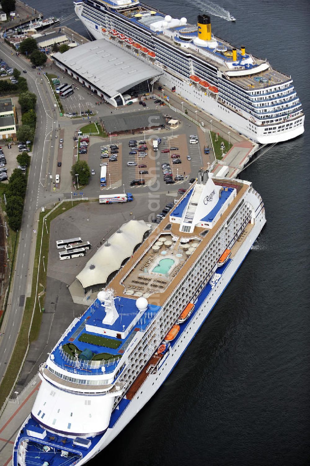 Aerial photograph Rostock - Warnemünde - Blick auf den Kreuzfahrt - Hafen in Warnemünde mit dem Passagierschiff Seven Seas Voyager . Die Seven Seas Voyager ist ein Kreuzfahrtschiff der Reederei Regent. View of the Cruise - Port of Rostock - Warnemünde with the passenger ship Seven Seas Voyager. The Costa Atlantica is a cruise ship for Regent.